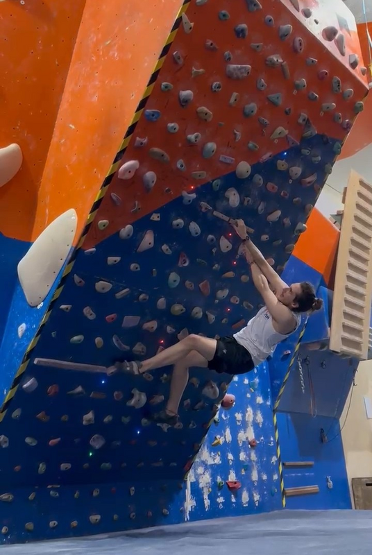 Pessoa escalando a parede do LEDge na academia Kmon